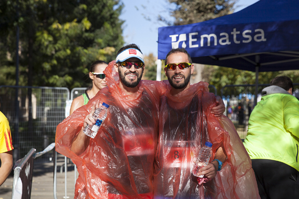 Dos corredores felices de haber acabado la carrera y resfrescándose con las botellas de agua de Ematsa
